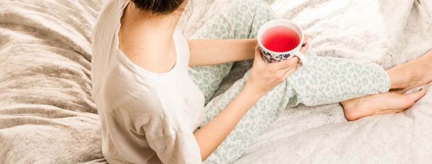mujer en actitud relajada y bebiendo una infusion como uno de los habitos de vida saludable