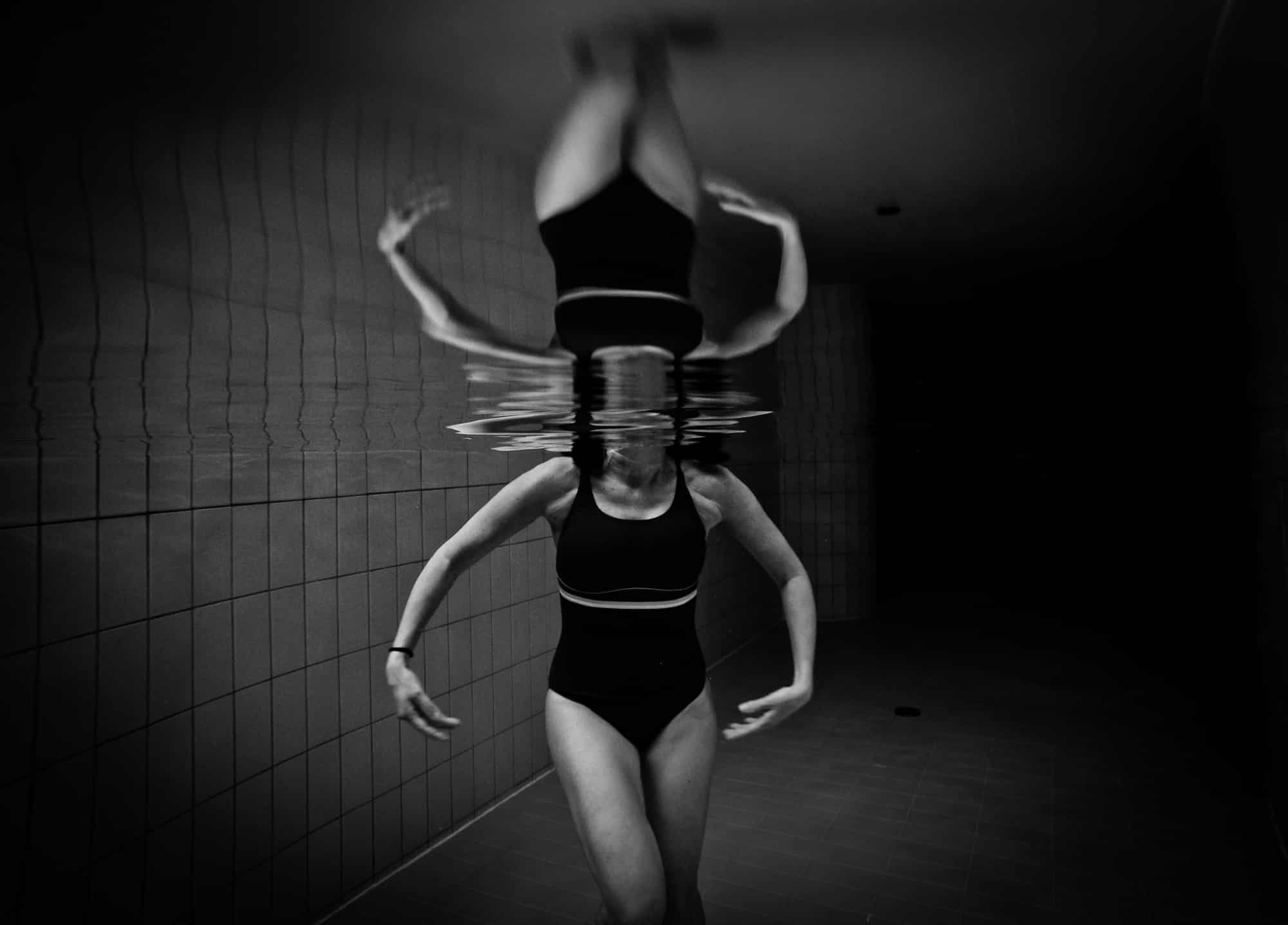 Mujer con bañador negro bajo el agua