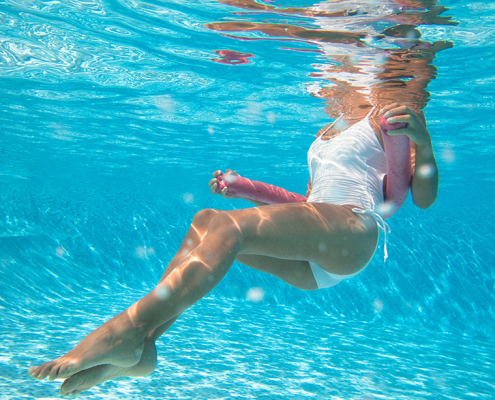Mujer con bañador blanco bajo el agua