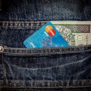 bolsillo de un jean con una tarjeta y un billete de 100 dólares