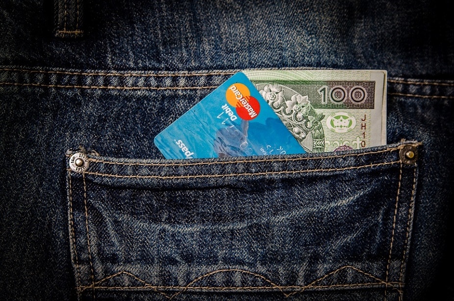 bolsillo de un jean con una tarjeta y un billete de 100 dólares
