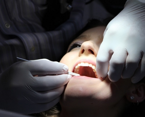 Mujer siendo intervenida por un dentista