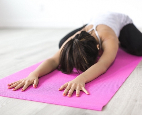 mujer practicando yoga, el cual es beneficioso para la gente que trabaja sentada