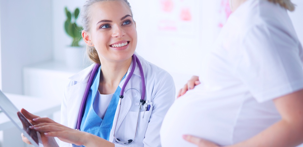 doctora hablando con su paciente embarazada sobre riesgos y coronavirus