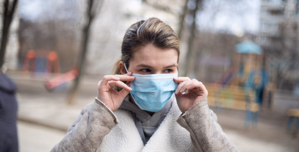 mujer llevando mascarilla por la gripe