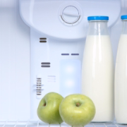 botellas de leche y manzanas en la nevera