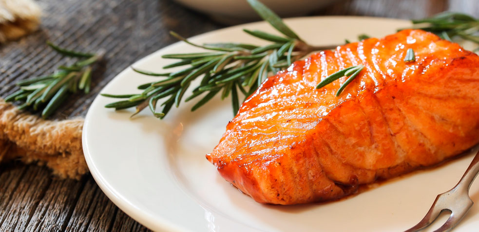 Trozo de salmón servido en un plato, beneficioso para las personas con colesterol