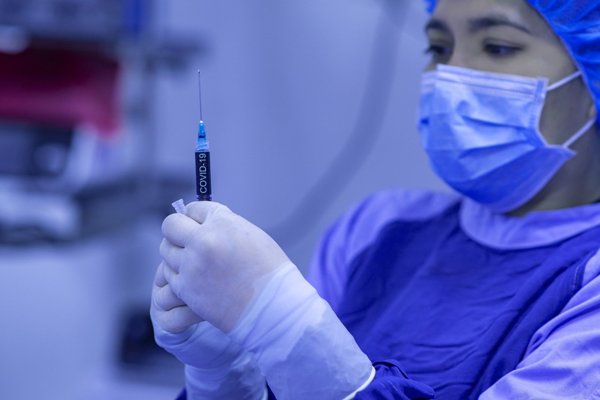 Personal sanitario sostiene en sus manos una vacuna antes de ser inyectada a un paciente 