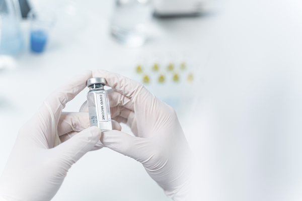 Personal científico sostiene una muestra de la vacuna del covid 19