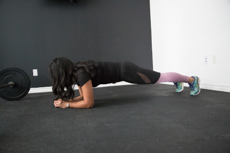 mujer haciendo ejercicio de plancha, se puede hacer en casa o en el gymnasio