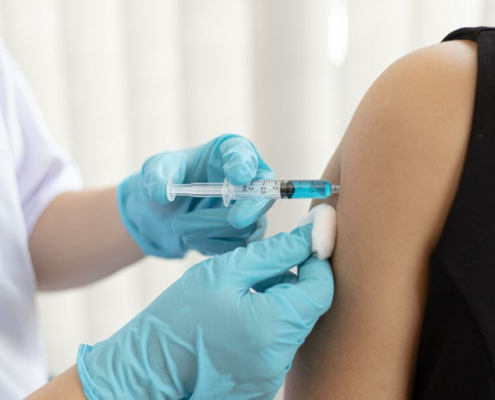 sanitaria poniendo la vacuna de la gripe