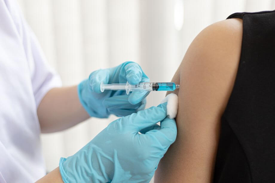 sanitaria poniendo la vacuna de la gripe