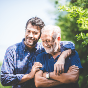 Adulto hijo y padre senior abrazados hablando cuidado personas mayores