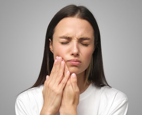 mujer tiene dolor de mandíbula fuerte