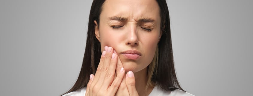 mujer tiene dolor de mandíbula fuerte