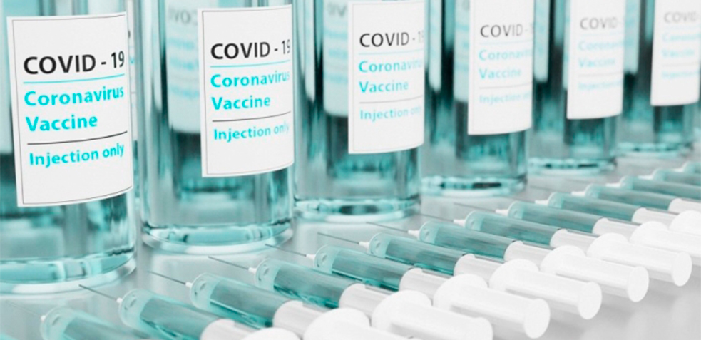 Vacunas del coronavirus apiladas junto a jeringuillas 