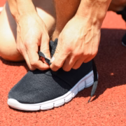 deportista atándose las zapatillas con placa de carbono