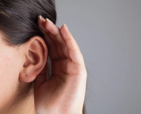 Mujer con mano en la oreja