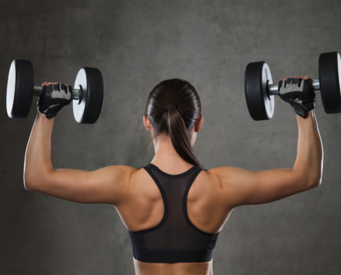 hipertrofia musculos mujer en el gimnasio haciendo pesas