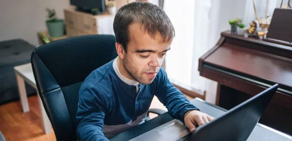 Hombre con acondroplasia trabajando desde casa