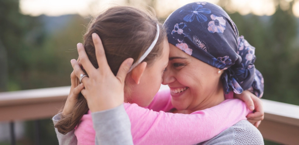 madre con cancer de mama abrazando a su hija 