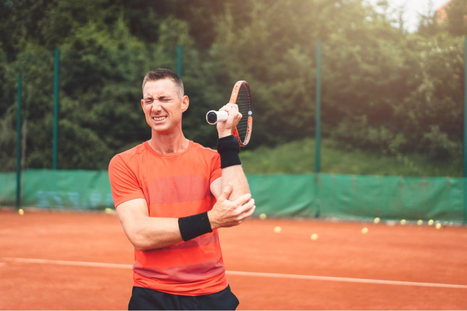 jugador de tenis doliendose del codo porque sufre epicondilitis