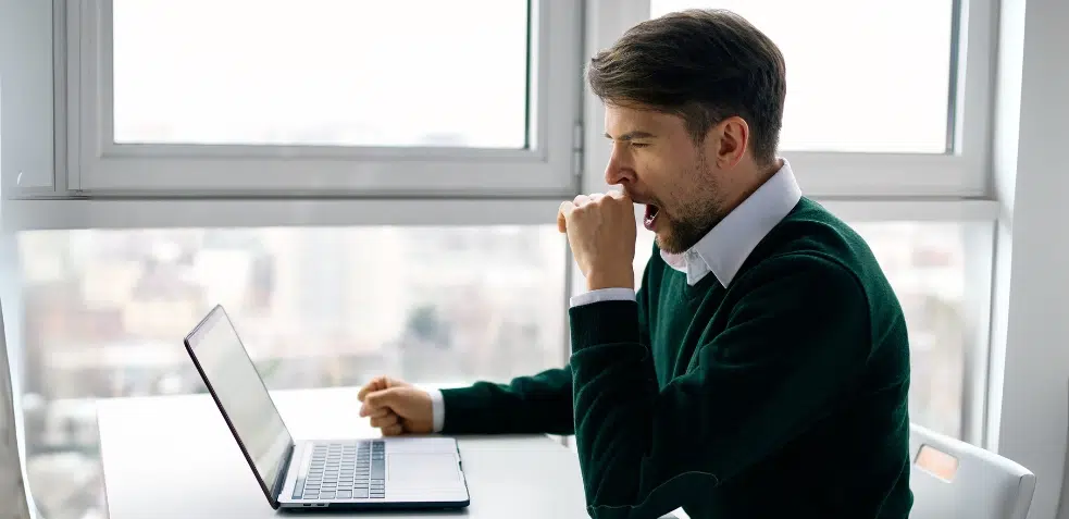 Hombre trabajando y bostezando con sueño