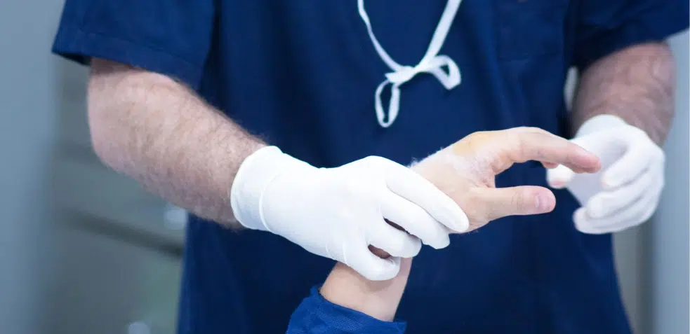 Doctor tratando sindactilia en la mano de un niño