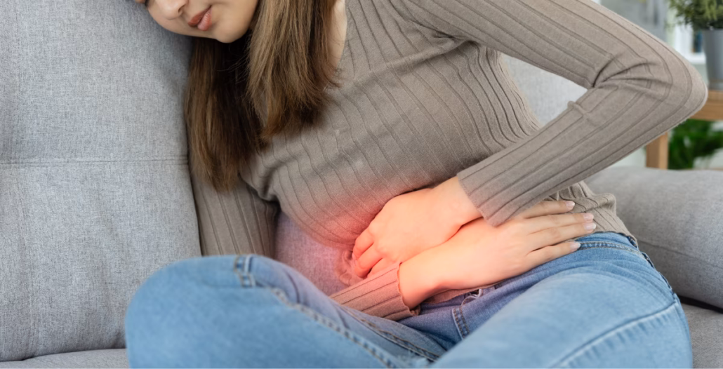 Chica con cólicos menstruales mostrando gesto de dolor
