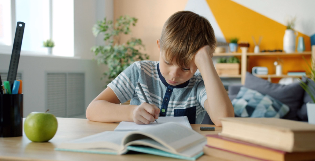 Niño realizando actividades de lenguaje con cuaderno y lápiz en casa