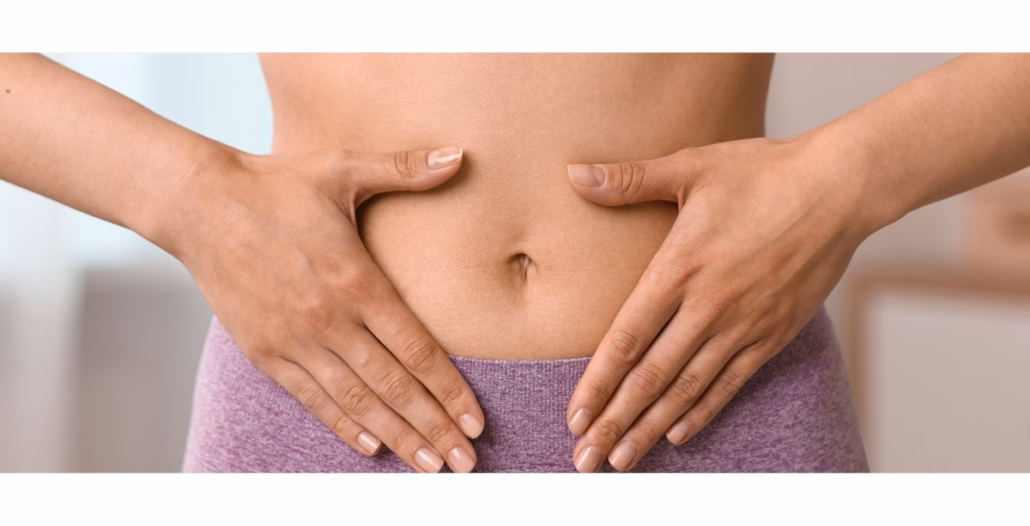 Plano corto de una mujer sujetándose el abdomen en señal de dolor o molestia asociada a pólipos uterinos